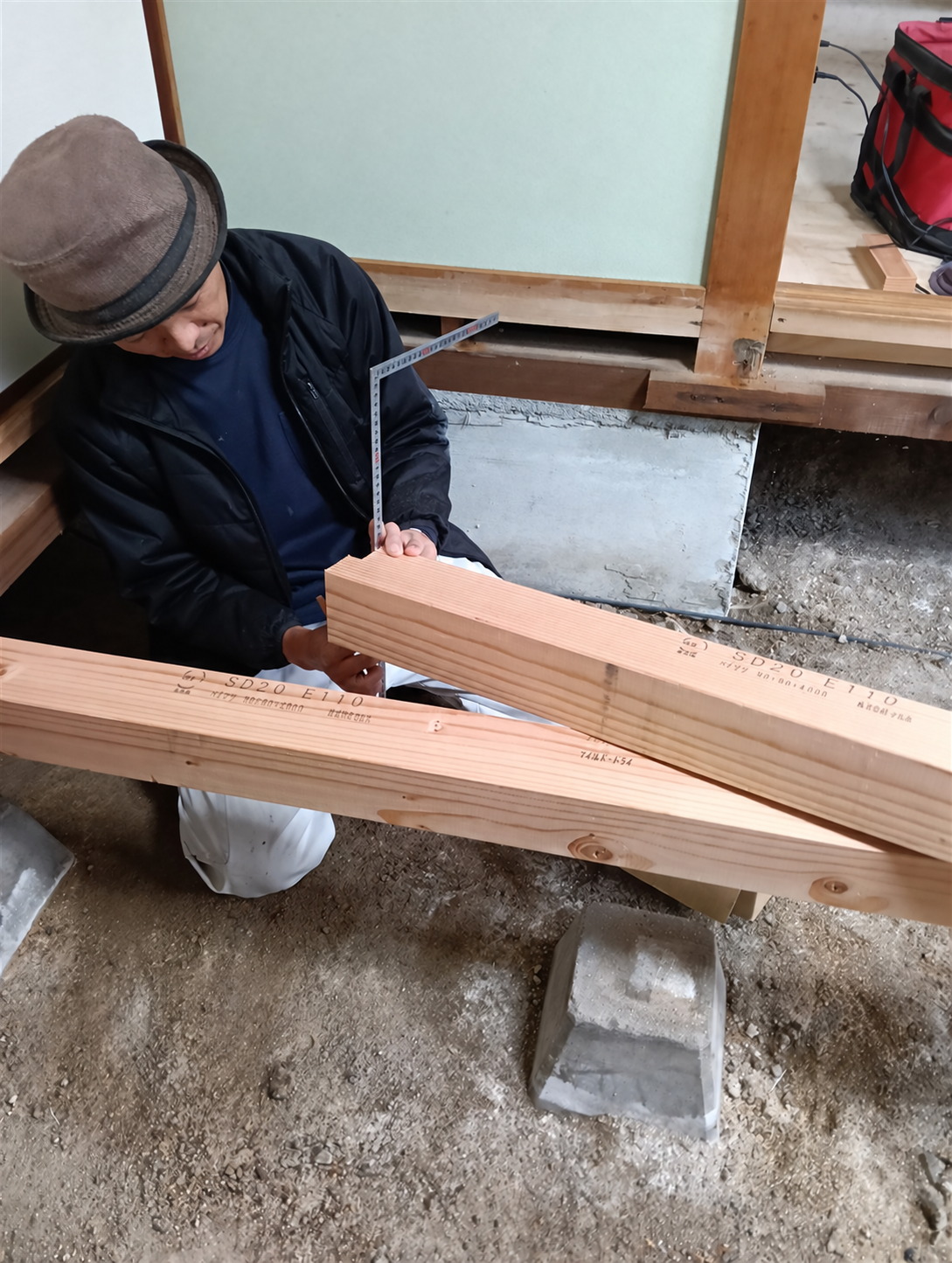 現場で木材の寸法を確かめる、うねさき建設の大工